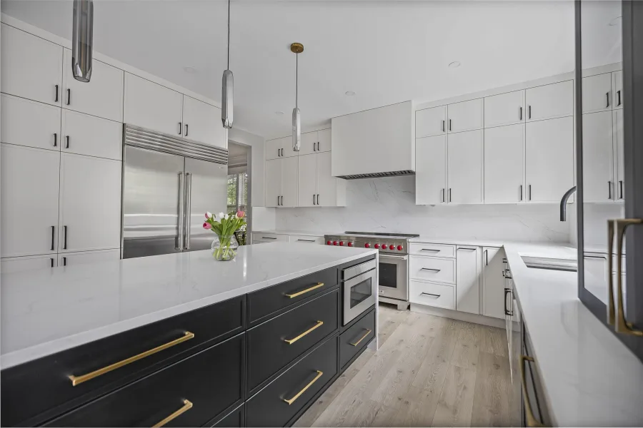 Two-tone kitchen with white cabinets, a dark island and gold hardware