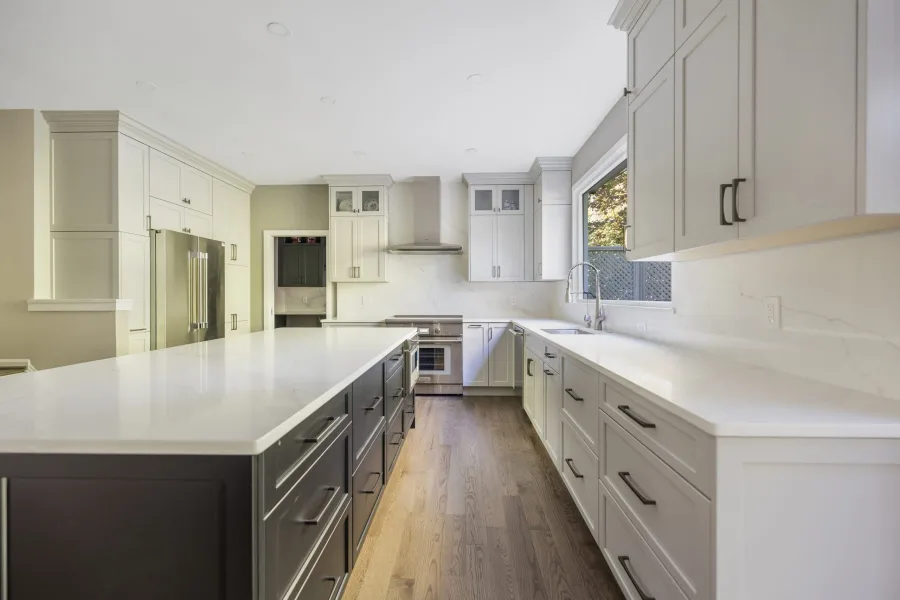 Kitchen with framed white cabinetry and marble countertops